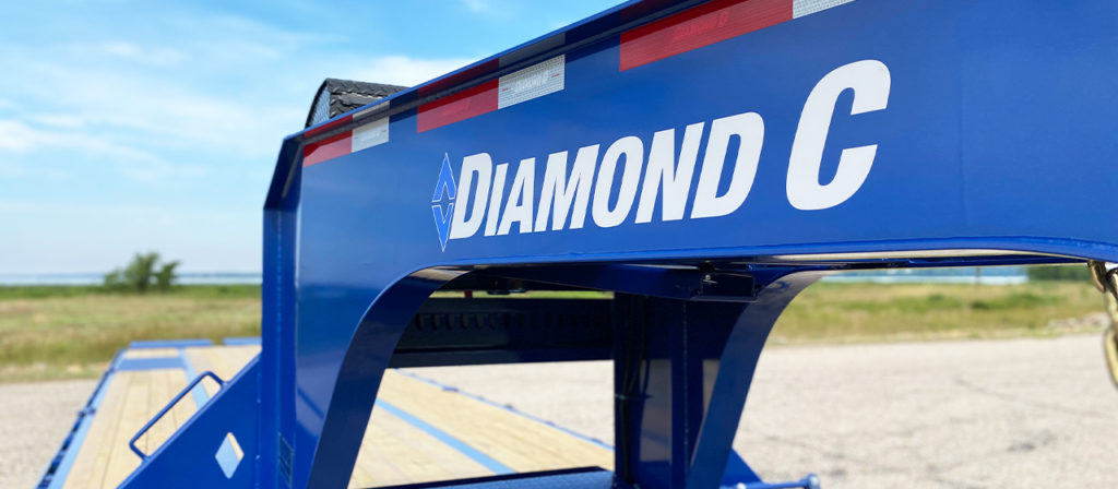 The Diamond C Trailers logo on the gooseneck of a blue model FMAX216