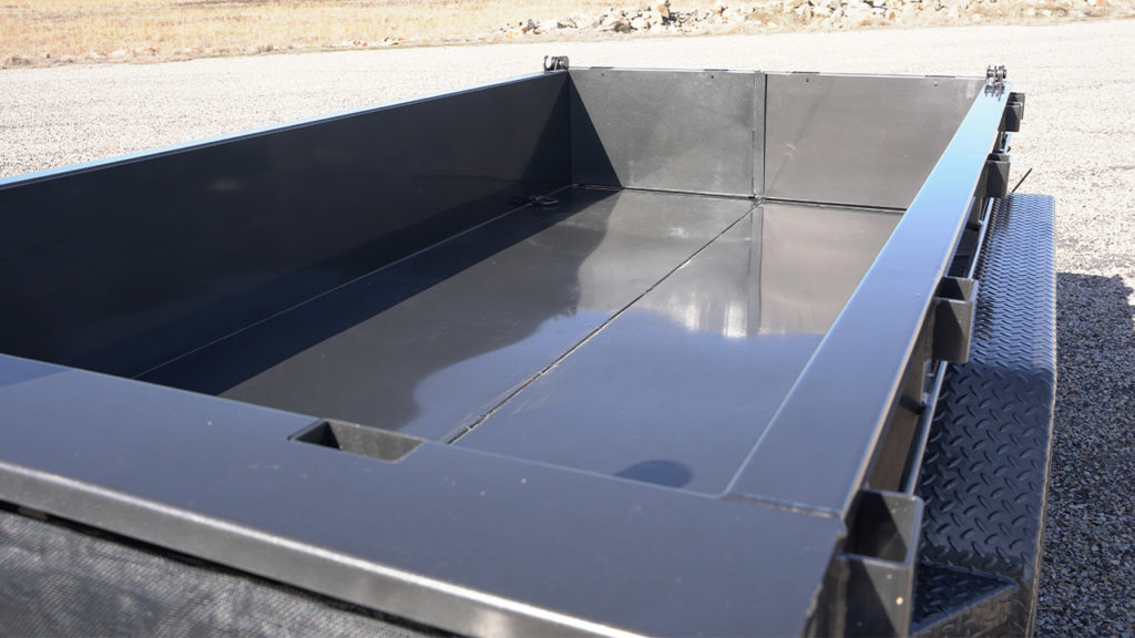 Dump trailer with thicker top rail standard