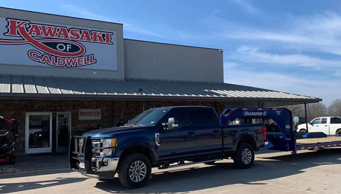 A Diamond C gooseneck trailer in front of Kawasaki of Caldwell.