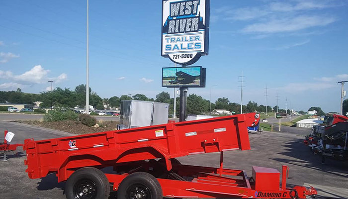 A Diamond C dump trailer in front of West River Trailer Sales sign.